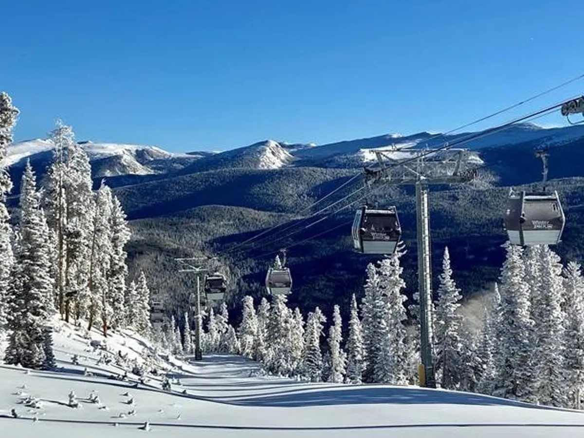 A dynamic winter exterior showcasing a ski lift ascending above snow-covered trees with a majestic mountain backdrop. Skiers and snowboarders can be seen enjoying the slopes, evoking the thrill of alpine exploration and easy access to outdoor adventure.